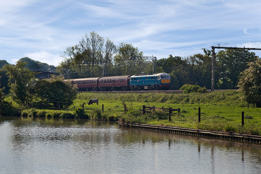 86259, outward leg of The Cumbrian Mountain Express, 07.10 London Euston-Carlisle (1Z86), Bugbrooke SP679564 
 Just before 86259 'Les Ross/Peter Pan' passed Bugbrooke in Northamptonshire hauling the outward leg of The Cumbrian Mountain Express the bull ate his way into the picture in the field the other side of the Grand Union Canal! He certainly adds a bit of extra interest to the image and somebody liked it as it was used in Rail Magazine! The sky has some high level Cirus uncinus clouds that do not usually present a threat weather wise, indeed, the day turned out to be a smashing one! 
 Keywords: 86259 The Cumbrian Mountain Express 07.10 London Euston-Carlisle 1Z86 Bugbrooke SP679564