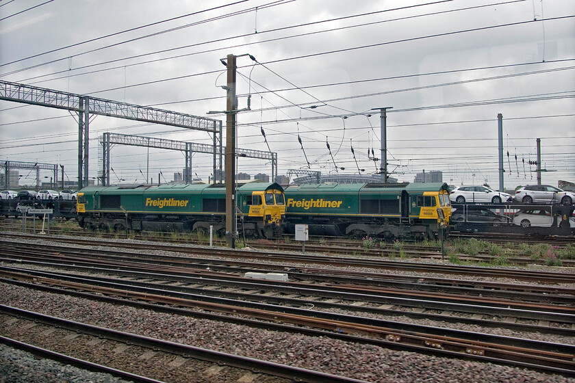 66554 & 66558, stabled, Wembley Yard 
 With a variety of new Toyota cars heading for export to the continent via the Channel Tunnel in the background, Freightliner's 66554 and 66558 await their next duties in Wembley Yard. After a few days of very welcome warm and dry spring weather, our day of return from London has reverted to type being grey and cool! 
 Keywords: 66554 66558 stabled Wembley Yard