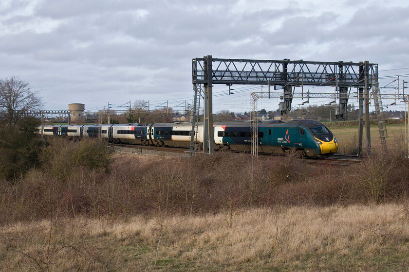 390044, 10.40 Glasgow Central-London Euston (1M11, RT), Roade Hill 
 This is a local spot that I have not visited for a number of years. It used to be a go-to spot for afternoon and evening photographs offering unrestricted views of both the up slow and fast lines, for example, https://www.ontheupfast.com/p/21936chg/24596067204/x88002-class-88-vip-launch-16-40 However, uncontrolled growth of scrub has rendered all but this restricted view completely blocked. 390044 'Royal Scot' passes working the 10.40 Glasgow to Euston service. 
 Keywords: 390044 10.40 Glasgow Central-London Euston 1M11 Roade Hill AWV Avanti West Coast