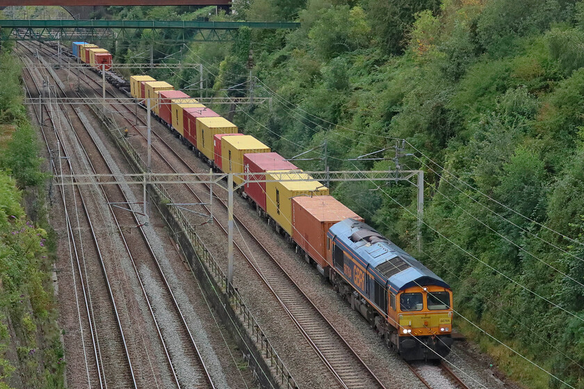 66764, 11.39 London Gateway-Hams Hall (4M47, 4L), Roade cutting 
 Due to the huge reduction in passenger traffic caused by yet more industrial action freight once again was routed along the fabled 'old line' via Weedon avoiding Northampton. 66764 'Major John Poyntz - Engineer & Railwayman' leads the heavily loaded 4M47 11.39 London Gateway to Hmas Hall service through Roade cutting. This photograph is taken from a lightly used bridge that I have not been able to get to for the last eighteen months or so due to footpath closure precipitated by the construction of Roade's bypass. However, with it now having opened access is again permitted to this very quiet spot at the very northern end of the cutting. 
 Keywords: 66764 11.39 London Gateway-Hams Hall 4M47 Roade cutting GBRf Major John Poyntz - Engineer & Railwayman