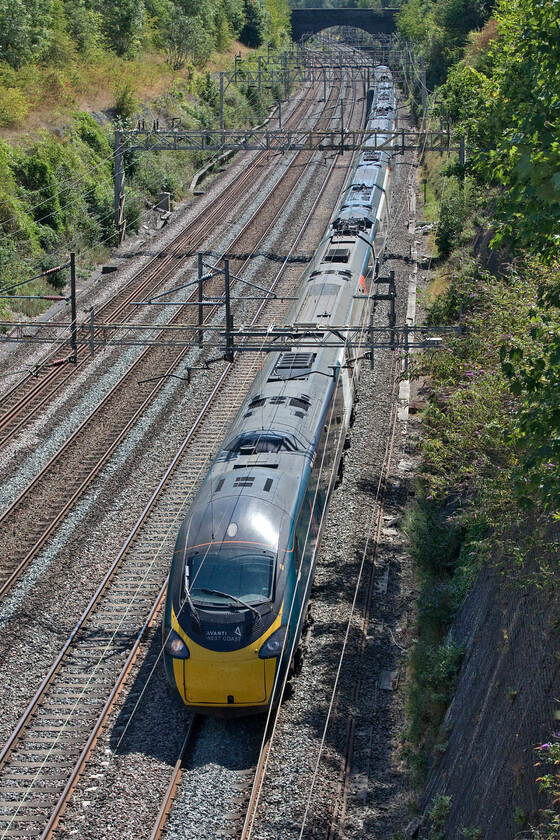 390148, VT 12.28 London Euston-Glasgow Central (1S63, RT), Roade cutting 
 390148 'Flying Scouseman' passes through Roade cutting working the 12.28 Euston to Glasgow Central Avanti service. This classic location on the WCML has not really changed a great deal since the wires were erected in the early 1960s, apart from the rampant vegetation growth, but the reverse angle to this one is about to look radically different with the construction of a new bridge that will carry Roade's much-awaited and much-needed bypass. 
 Keywords: 390148 12.28 London Euston-Glasgow Central 1S63 Roade cutting Pendolino Avanti West Coast Flying Scouseman