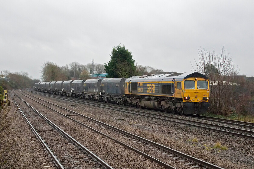 66707, 05.52 Washwood Heath-Tunstead Sidings (4H73, 7E), Sileby station 
 In pouring rain 66707 'Sir Sam Fay Great Central Railway' passes at speed leading the 4H73 05.52 Washwood Heath to Tunstead Sidings empty stone train. This working is in association with the construction of HS2 and will return full of stone to be used in the Birmingham area. When HS2 is completed, in whatever form it ends up being, the loss of the many stone workings will be noticeable throughout the country. 
 Keywords: 66707 05.52 Washwood Heath-Tunstead Sidings 4H73 Sileby station Sir Sam Fay Great Central Railway