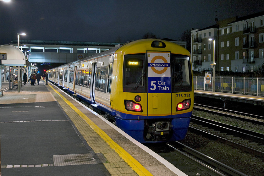 378214, LO 18.01 Clapham Junction-Stratford (2L74), Kensington Olympia station 
 I really think that the over-sized signs attached to the Class 378s are a little silly. Will London's travellers really be impressed that their new train has five cars when they are crammed like sardines in a train during peak hour travel? 378214 pauses at Kensington Olympia with the 18.01 Clapham Junction to Stratford London Overground service 
 Keywords: 378214 18.01 Clapham Junction-Stratford 2L74 Kensington Olympia station LO London Overground