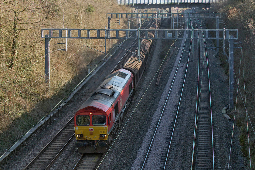 66137, 10.09 Dollands Moor-DIRFT (6M45), Hyde Road bridge 
 66137 is unfortunately in the shade as it passes through Roade with the 10.09 Dollands Moor to Daventry International Railfreight Terminal bottled water train. The picture is taken from Hyde Road bridge in the village. 
 Keywords: 66137 10.09 Dollands Moor-DIRFT 6M45 Hyde Road bridge