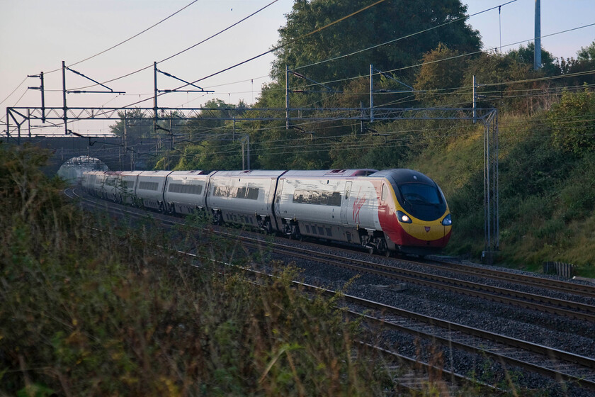 Class 390, VT 06.36 London Euston-Manchester Piccadilly (1H61), Roade Hill 
 An unidentified Class 390 heads north passing under Victoria bridge just south of Roade. Just catching a little early morning light being too deep in the small cutting to be directly illuminated the Virgin Pendolino is working the 06.36 Euston to Manchester Piccadilly. 
 Keywords: Class 390 06.36 London Euston-Manchester Piccadilly 1H61 Roade Hill Virgin Trains West Coast Pendolino