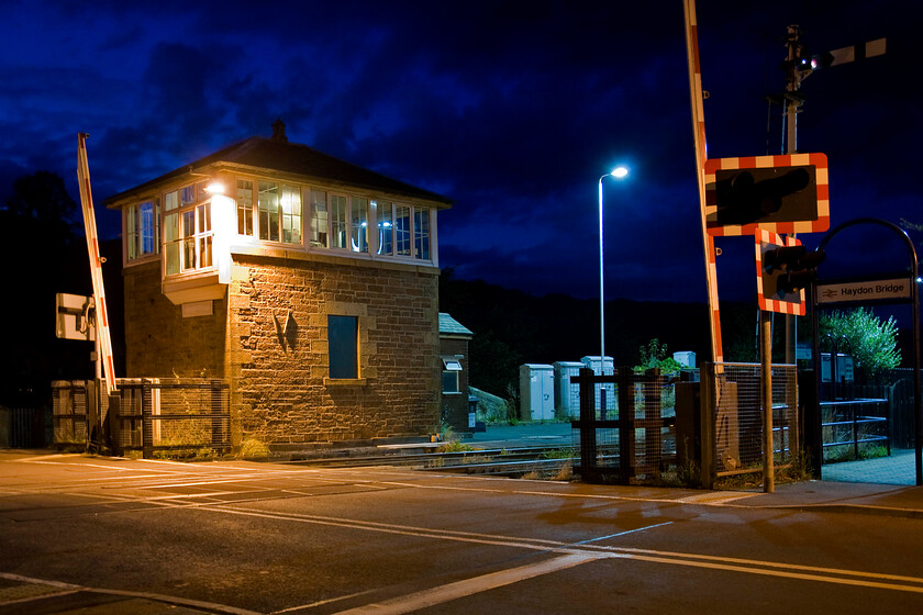 Haydon Bridge signal box (NE, 1877) 
 After our very disappointing evening meal at our hotel, Andy and I took a constitutional the short distance to the station at Haydon Bridge. The signal box seen on the platform end is a smart and early example of a North Eastern structure that, in this case, dates from 1877. In this view notice the non-standard and somewhat curious extension to the windows perhaps enabling the signalman to get a better view of the road prior to closing the gates. 
 Keywords: Haydon Bridge signal box North Eastern Railway