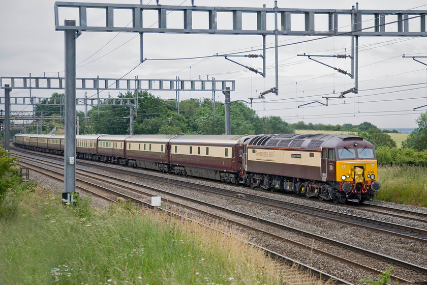 57305, outward leg of British GP special, London Euston-Milton Keynes-Rugby-Milton Keynes (1Z64), Ashton Road bridge 
 Having deposited its paying customers at Milton Keynes for their onward transportation to Silverstone by bus, The Northern Belle stock is hauled by 57305 'Northern Princess' near to Roade. It left Euston and travelled at a leisurely pace to Milton Keynes giving passengers plenty of time to take breakfast. It then ran to Rugby to return to Milton Keynes with more fare-paying passengers. Looking at the grey skies, it could be that the Grand Prix was one affected by rain. 
 Keywords: 57305 British GP special London Euston-Milton Keynes-Rugby-Milton Keynes 1Z64 Ashton Road bridge Northern Princess Northern Belle