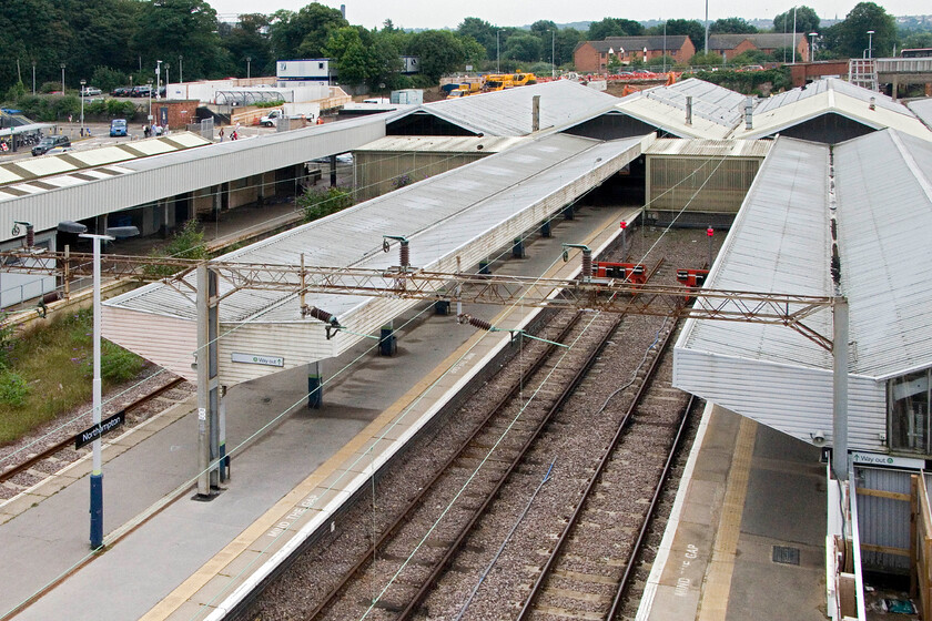 Platforms 1,2 & 3, Northampton station (from temporary footbridge) 
 This is not a view often seen! It shows the less commonly used north-facing bay platforms four and five at Northampton station. Along with the very rarely ever used parcels and Royal Mail platform, they are seen from the recently installed temporary footbridge installed whilst the station is redeveloped (for the third time in its history). I am not at all sure at this time what plans there are for these three platforms but they certainly ought to be used given the ever-increasing number of passengers using the station with 2.7 million entries and exits last year (2012-13). 
 Keywords: Platforms 1,2 & 3, Northampton station from temporary footbridge