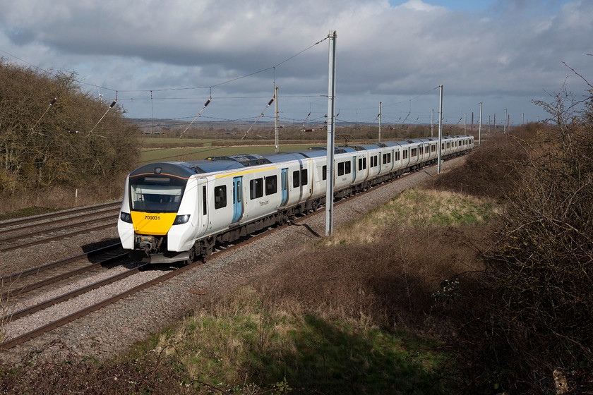 700031, TL 09.34 Bedford-Luton ECS (5H29), Millbrook TL020397 
 With the flat land know as Marston Vale in the background, 700031 approaches Millbrook with the 5H29 09.34 Bedford to Luton ECS working. A few years ago, this view would have been dominated by the many chimneys of the former brickworks that were situated here exploiting the clay close to the surface. Just to the right in the middle distance the four remaining chimneys can be made out. These are no longer in use and are preserved as a reminder of the area's industrial heritage. 
 Keywords: 700031 5H29 Millbrook TL020397