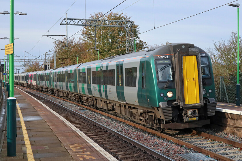 350108, LN 13.06 Birmingham New Street-London Euston (1Y42, RT), Wolverton station 
 After some awful west weather in the morning, that forced me to cancel my day's work and move it to a day with a better forecast, by late afternoon the clouds had cleared and the sun was making a half-hearted appearance! 350108 leads a classmate into Wolverton with the 13.06 Birmingham New Street to London Euston London Northwestern service. 
 Keywords: 350108 13.06 Birmingham New Street-London Euston 1Y42 Wolverton station London Northwestern Desiro