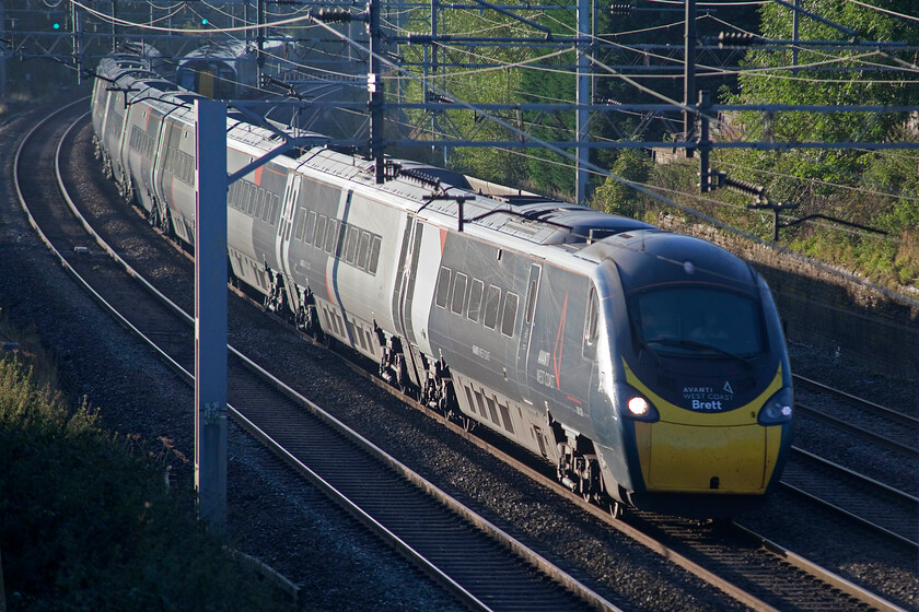 390129, VT 07.21 London Euston-Blackpool North (1P92, 1L), Little Bridgeford 
 390129 'City of Stoke-on-Trent' catches the early morning sun as it sweeps around the sharp curve at Little Bridgeford just north of Stafford working the 1P92 07.21 London Euston to Blackpool North. Notice that the cab also carries the name Brett which was applied during a short ceremony at Stocke station in April 2022. It was named in honour of the station's Duty Control Manager Brett Hobson who unfortunately died from cancer earlier in the year. 
 Keywords: 390129 07.21 London Euston-Blackpool North 1P92 Little Bridgeford Avanti West Coast Pendolino City of Stoke-on-Trent