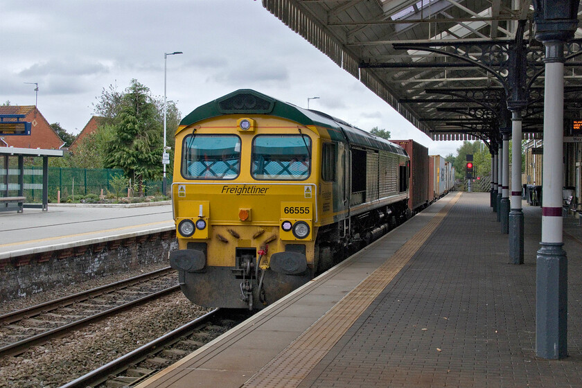 66555, 11.18 Tinsley Intermodal-Felixstowe North (4L85, RT), Spalding station 
 66555 is seen at speed passing through Spalding station leading the 4L85 Tinsley Intermodal (located in the old Tinsley Yard) to Felixstowe service. The train is about to head south-west to Peterborough and then after toying with the ECML for a short distance head east again towards March. This substantial dogleg could have been avoided if BR had not closed the direct GN & GE Joint line from here to March back in 1982. Had intermodal rail been at the levels it is today I suspect that the route would have been modernised and still open today. 
 Keywords: 66555 11.18 Tinsley Intermodal-Felixstowe North 4L85 Spalding station