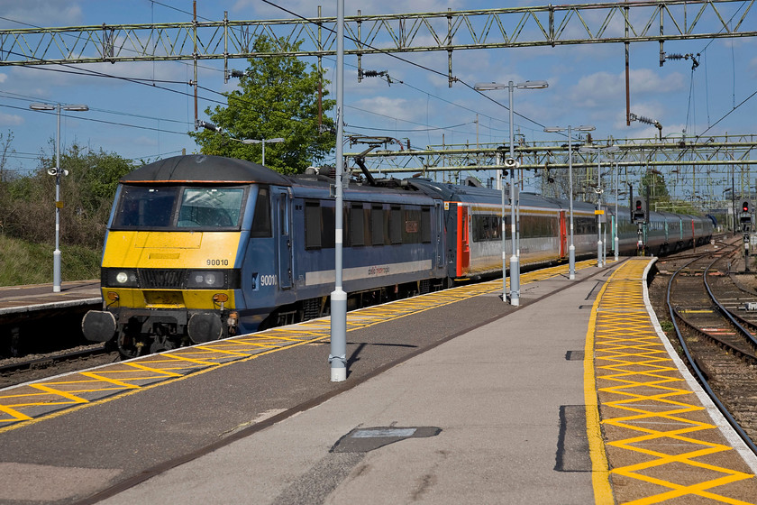 90010, LE 13.30 Norwich-London Liverpool Street (1P41), Witham station 
 90010 'Bressingham Steam & Gardens' rattles at speed through Witham station leading the 1P41 13.30 Norwich to Liverpool Street service. Whilst the locomotive and the bulk of the stock is in the older Greater Anglia livery the first two coaches look very smart in the Abellio version but for how long will it be maintained in this state? 
 Keywords: 90010 13.30 Norwich-London Liverpool Street 1P41 Witham station Bressingham Steam & Gardens Abellio Greater Anglia