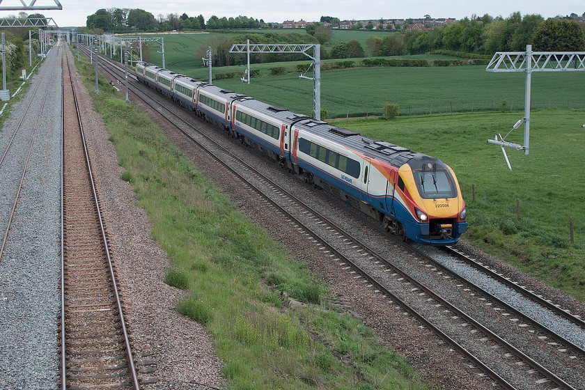 222006, EM 18.19 London St. Pancras-Sheffield (1F63, 25L), Irchester SP927667 
 222006 'The Carbon Cutter' passes Irchester on the MML working the 18.19 St. Pancras to Sheffield 1F63 working that arrived at its destination, like all other trains late, in this case, twenty-five minutes adrift. In this view, the stanchions are complete with the registration arms turned through 90 degrees awaiting the stringing of the wiring. At the moment, trains can be photographed with no obstruction, but once the various wiring is installed this view will be compromised. 
 Keywords: 222006 18.19 London St. Pancras-Sheffield 1F63 Irchester SP927667