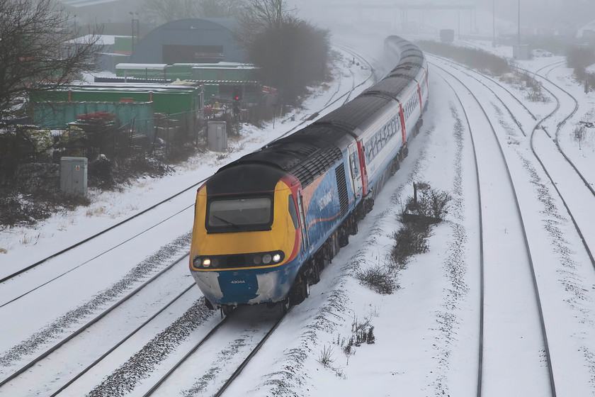 43044, EM 07.30 Nottingham-London St. Pancras (1B18, 1L), Wellingborough Finedon Road bridge 
 It's almost as some kind sole has cleared the front of 43044 so that I could identify the power car! The 07.30 Nottingham to St. Pancras comes around the curve past Findon Road sidings on the approach into Wellingborough in miserable conditions. 43044 was a 1977 Crewe built example that started its life on the ECML. Personally, I think that this East Midlands' livery is one of the best that hey have ever had. The HSTs look as fresh and modern as when they were introduced 40 years ago.....thoughts anybody? 
 Keywords: 43044 1B18 Wellingborough Finedon Road bridge