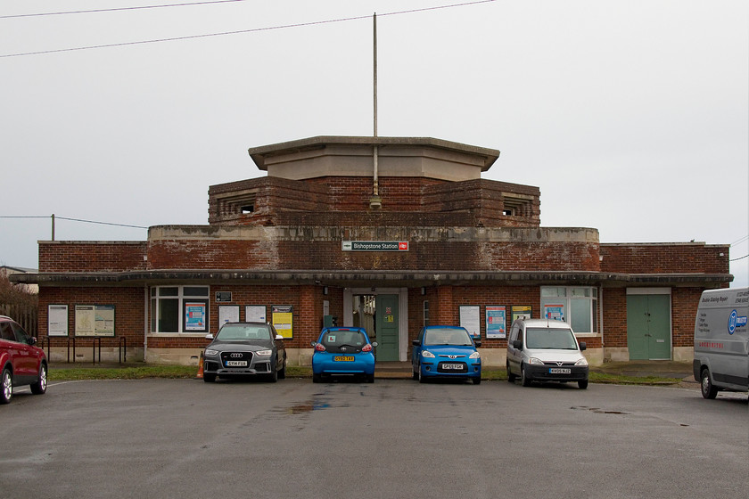 Frontage, Bishopstone station 
 The unusual design of Bishopstone station is clear in this image. Constructed in 1938, the station was designed by the Southern's chief architect James Robb Scott in the art deco style. The main building of the station is symmetrical, with an octagonal central booking hall and two extended wings. One of these wings formerly contained the ticket office and parcels office, now it is boarded up, was rather dismal and smelled of urine! Notice the two pill boxes on the roof added in 1940. Surprisingly, given it was war time, they have been sympathetically blended to the original structure. Yes, that is my trusty Combo van parked in front of the building! 
 Keywords: Frontage Bishopstone station