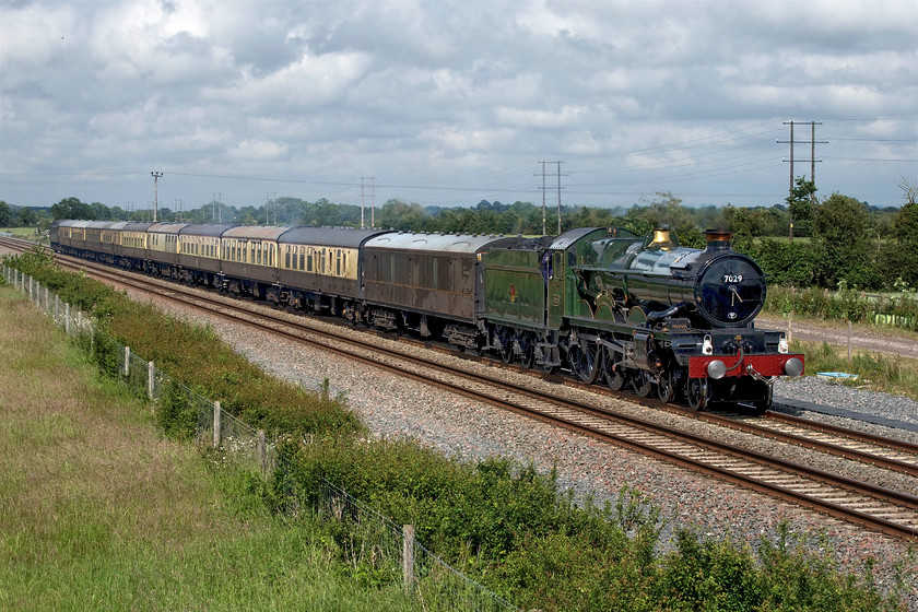 7029, return leg of the Oxford 175 Luncheon Circular, 15.45 Princes Risborough-Oxford (1Z71), Oddington SP542160 
 7029 'Clun Castle' rushes past Oddington between Oxford and Bicester with the returning Oxford 175 Luncheon Circular railtour running as 1Z71, the 15.45 Princes Risborough to Oxford. There is very little exhaust from the Castle that is a shame as, despite the welcome sunshine, the mid-summer light has created a very contrasty image with very deep shadows. Whilst Photoshop has been used to tinker with the image, it is still somewhat unsatisfactory. 
 Keywords: 7029 Oxford 175 Luncheon Circular 15.45 Princes Risborough-Oxford 1Z71 Oddington SP542160