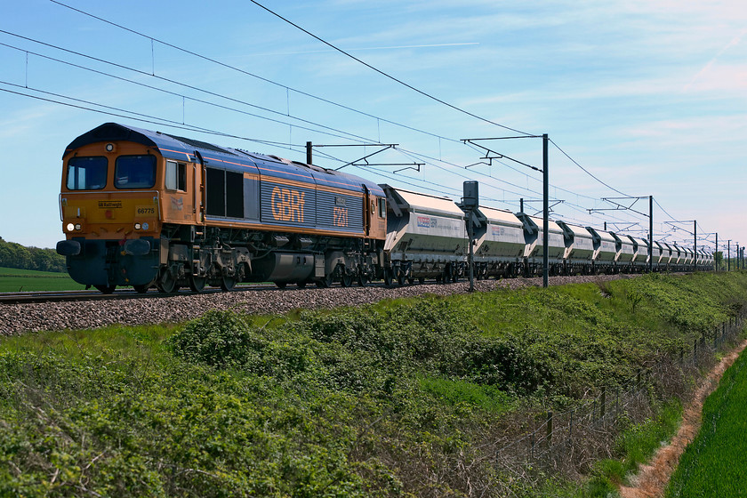 66775, 08.30 Middleton Towers-Monk Bretton (6E84), Frinkley Lane crossing SK906436 
 66775 'HMS Argyll' leads the relatively lightly loaded 08.30 6E84 Middleton Towers to Monks Bretton sand train. It is seen, taken in tricky lighting, about to cross Frinkley Lane crossing, previously a level crossing now closed to all but pedestrians, cyclists and horse riders. We had been waiting for this train for some time as it was held over at the top of Stoke bank in the loop waiting for a slot to enter the two-track section so as to avoid holding up down passenger express workings. 
 Keywords: 66775 08.30 Middleton Towers-Monk Bretton 6E84 Frinkley Lane crossing SK906436