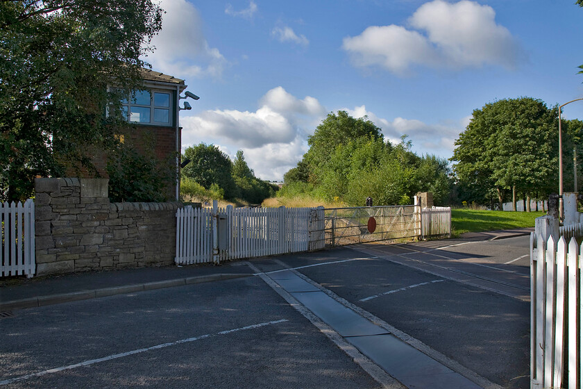 Daisyfield (Station) signal box (L&Y, 1873) & level crossing 
 A view of the Moss Street level crossing in Blackburn with its controlling signal box, delightfully named Daisyfield, to the left partially obscured by the trees. The single line in the foreground heads roughly north east along the Ribble Valley ending up at Hellifield. However, at the present time passenger trains only go as far as Clitheroe with plans under discussion to extend them to the Settle and Carlisle station. 
 Keywords: Daisyfield Station signal box L&Y level crossing Lancashire and Yorkshire Railway