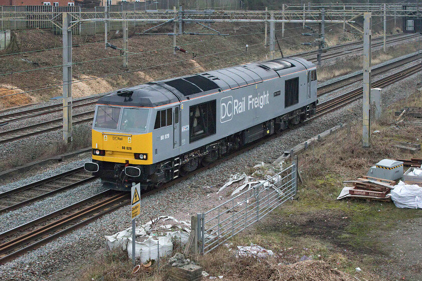 60029, 07.07 Chaddesden Sidings-Wembley Reception (0Z45, 3L), site of Roade station 
 Looking very smart in its DC Rail Freight livery 60029 'Ben Nevis' passes the site of Roade station as the 0X45 07.07 Chaddesden Sidings (Derby) to Wembley Reception sidings light engine. Class 60s are not common on the WCML so are always worth the extra effort, despite the unpleasant weather, especially as this particular example is a photographic cop! The purpose of this move was to get the Class 60 to the North London area in order to work HS2 infrastructure trains. Notice in the background evidence of recent embankment clearance that took place over a ten-day possession of the fast line at the start of the year. 
 Keywords: 60029 07.07 Chaddesden Sidings-Wembley Reception 0Z45 site of Roade station light engine Ben Nevis