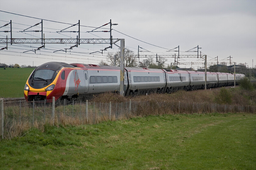 390045, VT 08.07 London Euston-Liverpool Lime Street, Gordon's Lodge SP776483 
 390045 '101 Squadron' passes Gordon's Lodge just north of Hamslope Junction working the 08.07 Euston to Liverpool Lime Street service. Like many Pendolins working on the WCML this one is charging along with its couping door open doing nothing for air-cheating aerodynamics. 
 Keywords: 390045 08.07 London Euston-Liverpool Lime Street Gordon's Lodge SP776483 Virgin West Coast Pendolino 101 Squadron