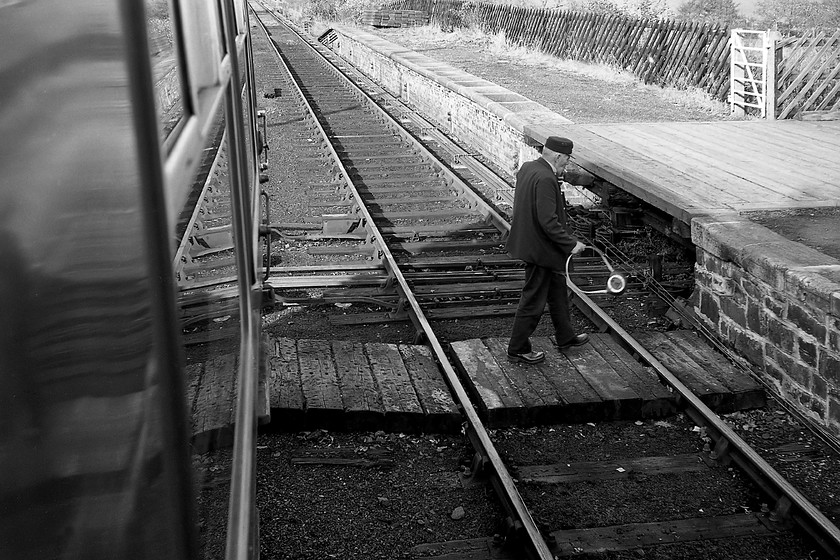 Driver exchanging the token, from 10.13 Whitby-Middlesborough, Glaisdale station 
 Looking very smart in his traditionally ill-fitting BR uniform with highly polished shoes and a cigarette dangling from his mouth the driver of the 10.13 Whitby to Middlesborough crosses the track in order to pass the token to the signalman at Glaisdale on the Esk Valley line. The delightfully anachronistic activity is largely the preserve of the heritage line now with me struggling to think of anywhere on the network with single line working and semaphores where a tablet is exchanged?

There is an audio recording of this DMU leaving Glaisdale on my Youtube channel, see...https://youtu.be/Z7aMJ1vsmmU 
 Keywords: exchanging the token 10.13 Whitby-Middlesborough Glaisdale station