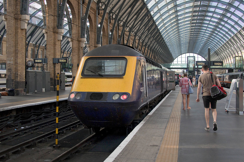 43027 HT 18.48 London King`s Cross-Hull (1H06, 7L), London King`s Cross station 
 With Hull Trains still having major problems with the availability of its class 180 DMUs (themselves cast-offs from First Great Western), they are forced into hiring in ex Great Western HSTs from Angel Trains! How ironic that despite the intense heat and the heavy work that is expected of them, these evergreen HSTs are still able to get on with the job far more reliably than the glorified DMUs less than half their age! 43027 (of the former Western region set 253013) waits at the rear of the 18.48 departure to Hull. 
 Keywords: 43027 18.48 London King`s Cross-Hull 1H06 London King`s Cross station