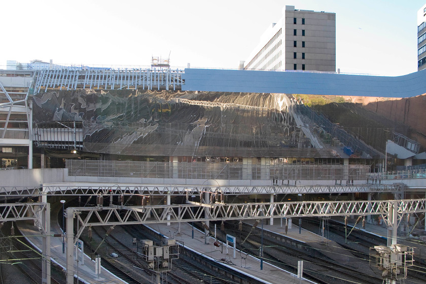 Rebuilding, Birmingham New Street station 
 The platform ends of New Street station are unmistakeable down below street level in this view. However, the complete rebuilding of the upper part of the station is completely changing its appearance beyond recognition. The highly reflective cladding is being attached to the framework that itself has been fixed to the building. The redevelopment of the station is due to be completed this year having been started in 2012 . 
 Keywords: Rebuilding Birmingham New Street station