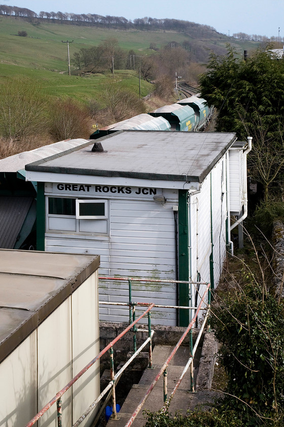 Great Rocks Junction signal box (Midland, 1923) 
 Quite unbelievably, Great Rocks Junction signal box is of an identical vintage to the previous box seen on this trip, see.... https://www.ontheupfast.com/v/photos/21936chg/28004564404/peak-forest-south-signal-box In fact, this box predates Peak Forest South by two years but its present drastically altered design would not tell you this. At some time in the past, the roof was removed and it was then painted in a hideous orangy-yellow colour. Finally, in the early 2000s it was clad in uPVC with the toilet block added on the far end. Hard to recognise it as a 1923 Midland type 4d box but that is what it actually is! 
 Keywords: Great Rocks Junction signal box