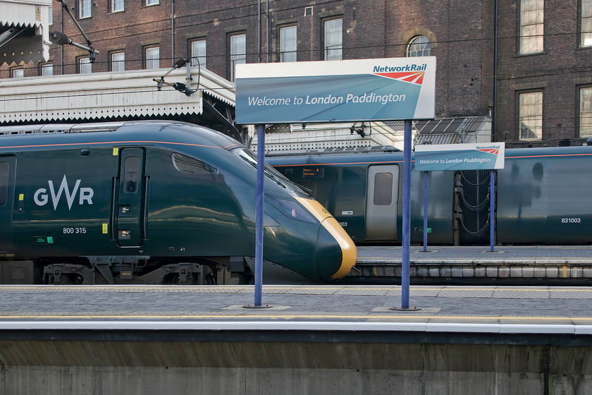 800315, GW 11.31Weston-super-Mare-London Paddington (1A16, 6L) & 802003, GW 14.03 London Paddington-Penzance (1C84, RT), London Paddington station 
 Paddington station is a very different place to the one that I knew from my time as a young spotter in the 1970s. Visually it is much altered with the arrival of the electrification wiring and of course, the actual trains are all new. However, the thing that I noticed during this particular visit was that it was so quiet. There was not one diesel train observed on this Sunday afternoon with IETs gliding silently in and out of the station all very different to when Class 50s and Westerns sat at the blocks after arriving from the West Country. In this scene, 800315 has just arrived with the 11.31 from Weston-super-Mare whilst 800003 will soon leave with the 14.03 to Penzance. 
 Keywords: 800315 11.31Weston-super-Mare-London Paddington 1A16 802003 14.03 London Paddington-Penzance 1C84 London Paddington station Great Western Railway IET