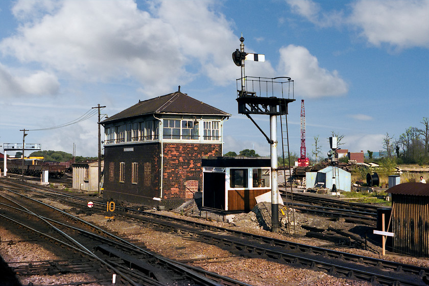 Westbury South signal box (GW, date unknown, on day of closure) 
 Taken from my return train as it enters Westbury from the south. Westbury South signal box is seen on its final day of operation. At midnight it was switched out and decommissioned as the first phase of the Westbury MAS programme was initiated. Some colour lights installed and ready to go can be seen to the left and right of the signal box that were controlled by a mini-panel installed in Westbury North box. I have seen very few pictures of the south box, partly due to its inaccessible location, and have no details as to when it was built; can anybody help? When the box closed about seven hours after this picture was taken, I wonder where the cast plate ended up? 
 Keywords: Westbury South signal box