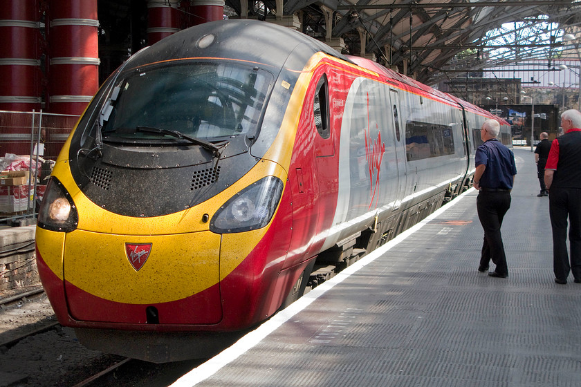 390137, VT 11.07 London Euston-Liverpool Lime Street (1F15), Liverpool Lime Street station 
 The driver of Pendolino 390137 brings his train carefully to a halt at Liverpool Lime Street as the train terminates with the 11.07 from London Euston. Notice the trio of Virgin staff who, along with a team of cleaners, wait to board the train to prepare it during its short turnaround and its departure to London again. 
 Keywords: 390137 11.07 London Euston-Liverpool Lime Street 1F15 Liverpool Lime Street station Virgin Pendolino