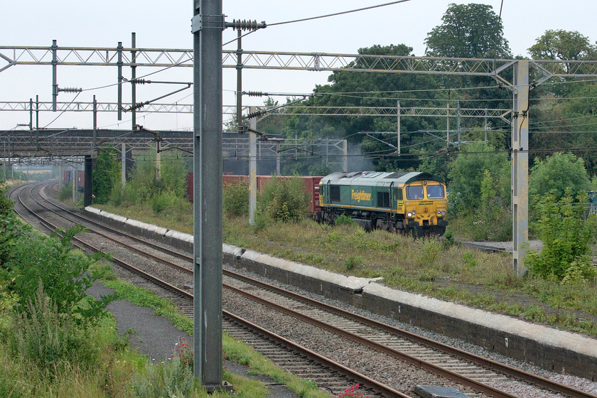 66550, 12.16 Lawley Street-Felixstowe North (4L46, 1L), site of Castlethorpe station 
 The first of two up freights heading south past Castlethorpe within four minutes of each other! Freightliner's 66550's exhaust is smoking well as it leads the 4L46 12.16 Lawley Street to Felixstowe. Since my last visit to this particular spot, the growth of saplings on the former island platform is beginning to interfere with the opportunities to take photographs. The gap that the locomotive is seen in is really the only chance one now has to capture a locomotive that is not partially or completely obscured. 
 Keywords: 66550 12.16 Lawley Street-Felixstowe North 4L46 site of Castlethorpe station Freightliner