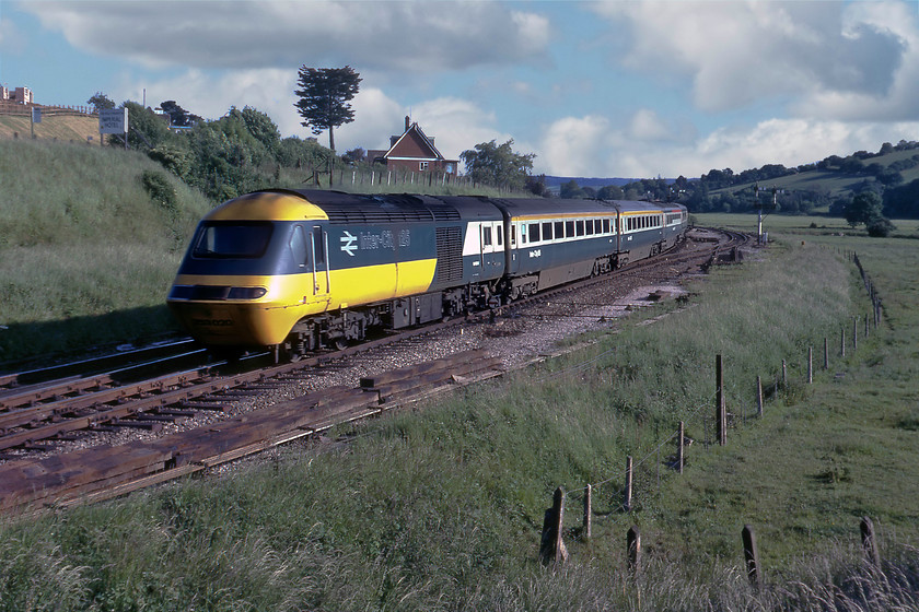 253020, 15.37 Penzance-London Paddington, Cowley Bridge Junction 
 In mid-1980 HSTs were still being introduced to the South West taking over a number of the principal express services to and from Paddington but things had not quite gone to plan with a number of teething problems blighting BR's much-heralded roll out of the Intercity 125 brand on this route. I must admit remembering disappointment when one passed at this time as in all likelihood it would have been Class 50 hauled previously. However, in retrospect, I am pleased that I did not ignore their passing and took photographs of them in their classic and 'as introduced' livery. Here set 253020 accelerates away from its stop at Exeter passing Cowley Bridge Junction working the 15.37 Penzance to Paddington service. This power car would be one of either 43040 or 43041 that both carried on working trains to and from Paddington passing this spot too many times to mention until their withdrawal from service in 2019 after over forty years of operation; quite an incredible feat! 
 Keywords: 253020 15.37 Penzance-London Paddington Cowley Bridge Junction HST 43040 43041