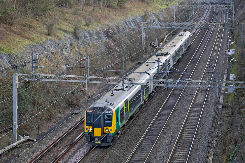 350373, LM 11.54 London Euston-Northampton (2N13), Roade cutting 
 350373 passes through Roade cutting working the 11.54 Euston to Northampton London Midland service. This particular unit is one member of a ten-strong subset numbered 350368 to 350377. They are built with one hundred and ten miles per hour operation and were introduced during 2014 for use on the longer distance journeys that use the fast lines particularly in the north-west. 
 Keywords: 350373 LM 11.54 London Euston-Northampton 2N13 Roade cutting London Midland Desiro