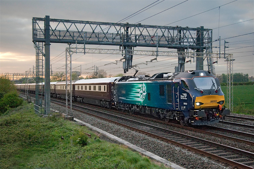 88002, return leg of The Class 88 VIP Launch, 16.40 Carlisle-London Euston (1Z89), Roade Hill 
 With the light pushing the camera to the limits, 88002 'Prometheus' passes Roade Hill with the return leg of the The Class 88 VIP launch. As the name suggests, this was train that ran to mark the introduction of the bi-mode class 88s that ran as 1Z89 from Crewe back to Euston. Out of sight on the rear was 68022 'Resolution'. 
 Keywords: 88002 The Class 88 VIP Launch 16.40 Carlisle-London Euston 1Z89 Roade Hill