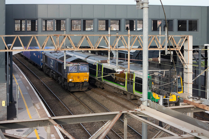 66434, 13.01Daventry-Purfleet (4L48) & 350245, LM 11.37 Crewe-London Euston, Northampton station 
 As we passed DIRFT on our journey back from Birmingham, I observed 66434 waiting to leave the confines of the depot with the 4L48 13.01 Freightliner to Purfleet. By the time we had alighted from our train at Northampton, gone through the barriers and walked round to the Spencer Bridge road bridge, it was in the station being brought to a halt at the up middle road signal. This wait enabled 350245, working the 11.37 Crewe to Euston, to get out in front of it. 
 Keywords: 66434 13.01Daventry-Purfleet 4L48 350245 11.37 Crewe-London Euston Northampton station