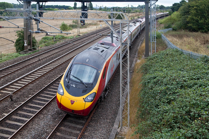 390153, VT 12.00 London Euston-Manchester Piccadilly (1H23, 6L), Old Linslade 
 I hope that the tilting mechanism on 390153 'Mission Accomplished' is working correctly as it takes the sharp and heavily cambered curve at Old Linslade. The Pendolino was working the 1H83 12.00 London Euston to Manchester Piccadilly. In this view, evidence of the dry conditions, that were such a feature of summer 2108, can be seen in the background with brown grass covering the meadow. 
 Keywords: 390153 1H23 Old Linslade