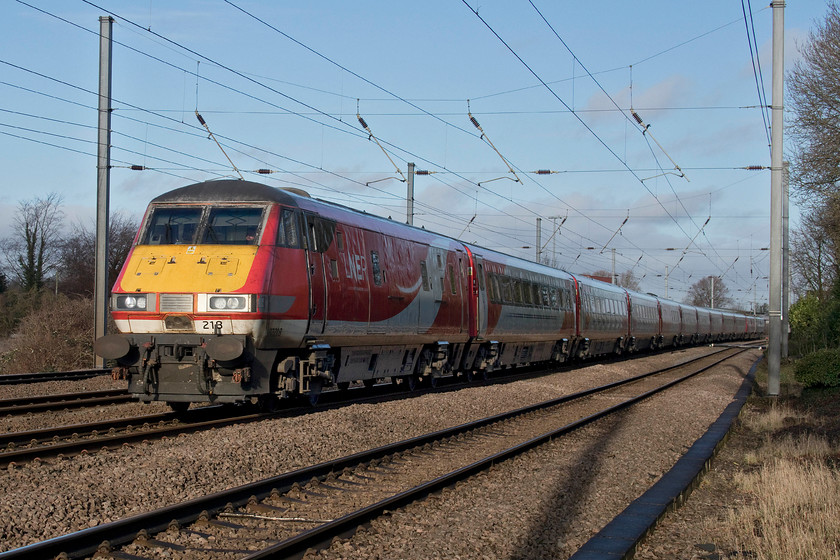 82218, 91106 & 91111, GR 10.45 Leeds-London King`s Cross (1A25, 1L), Gill`s Crossing 
 This is another working that I was surprised was still being operated by a Mk. IV 225 set assuming that an Azuma would be handling it by now, the 1A25 10.45 Leeds to St. King's Cross. In this photograph, the service is seen passing Gill's Crossing in the village Offord Cluny with 82218 leading. Close examination of the rear of the train reveals two Class 91s. 91106 is tucked inside running with its pantograph down with the power coming from 91111 'For the Fallen' at the very back. I am not sure if 91106 had failed but the train was running to time arriving at its destination only a minute adrift. 
 Keywords: 82218 91106 91111 10.45 Leeds-London King`s Cross 1A25 Gill`s Crossing LNER IC225 For the Fallen