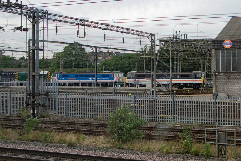 08671, 86401 & 86213, stabled, Willesden Depot 
 The AC Locomotive Group owns and maintains both 86401 'Northampton Town' and 86213 'Lancashire Witch' seen here along with resident shunter 08671. The Class 86s are facing an uncertain future with 86401 awaiting a wheelset change that it has been anticipated for some time now. With the train supply contract work having dried up a while ago 86213 has no work. The two locomotives look smart in their respective retro. liveries evoking times past at Willesden Depot. 
 Keywords: 08671 86401 86 213 Willesden Depot