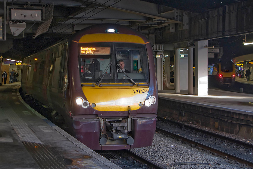 170104, XC 16.19 Birmingham New Street-Nottingham (1D70), Birmingham New Street station 
 The interior of New Street station is not a location conducive to taking photographs. This image illustrates the problem, here showing 170104 preparing to leave with the 16.19 to Nottingham. In the background, a CrossCountry Voyager is seen waiting to leave for the West Country. 
 Keywords: 170104 16.19 Birmingham New Street-Nottingham 1D70 Birmingham New Street station