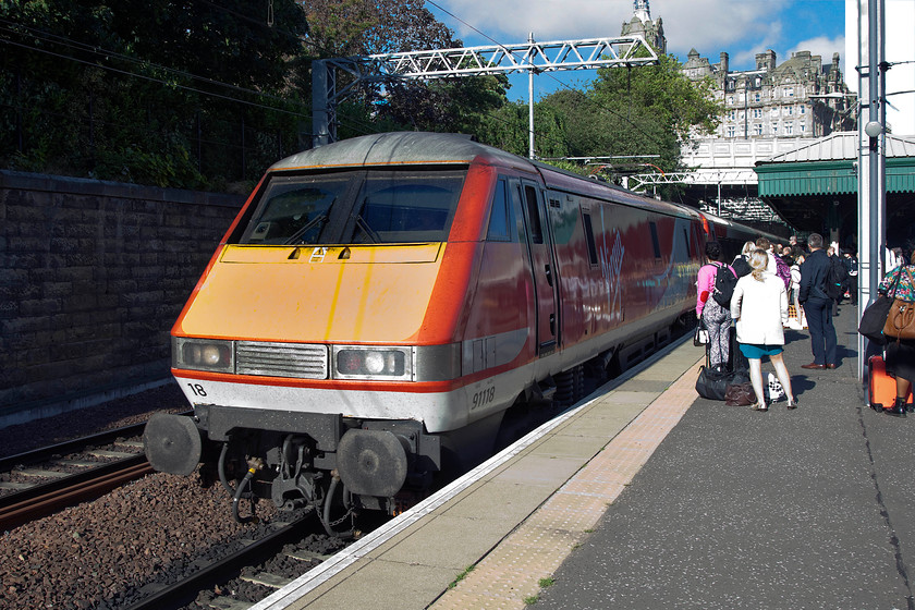 91118, GR 11.30 London King`s Cross-Edinburgh Waverley (1S15), Edinburgh Waverley station 
 91118 has just arrived with the 11.30 from King's Cross at Waverley station. In the annals of time I am not quite sure what all the passengers, milling about on platform nineteen, are waiting for? It must be the following train as the 91 hauled service was terminating. Notice the imposing former North British Hotel in the background, regular readers will be aware of my spotting friend and companion Andy. This hotel holds a special place in his heart as he spent the first night of his honeymoon there no doubt hanging out of the window getting numbers rather than paying appropriate and considerate attention to his bride! 
 Keywords: 91118 11.30 London King`s Cross-Edinburgh Waverley 1S15 Edinburgh Waverley station