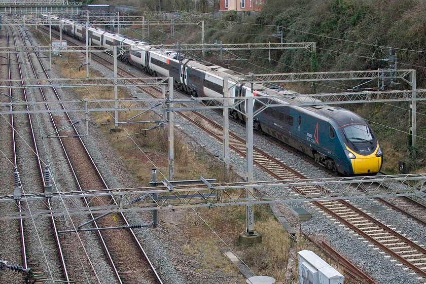 390157, VT 13.15 London Euston-Crewe (9S77, 3L), A508 bridge 
 I have never taken an image of a train on the down fast line from this position. However, I am able to do so now as the Roade bypass has recently opened meaning that it is now relatively safe to stand on the old A508 bridge where there is no footpath. The image is tricky to frame due to the high parapet of Bridge 207 meaning the flip-out screen has to be used and reaching upwards. When I am braver, I will take some steps and hope that the road remains as quiet as it is now! 
 Keywords: 390157 13.15 London Euston-Crewe 9S77 A508 bridge AWC Avanti west coast Pendolino