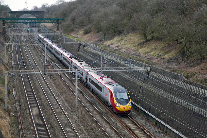 Class 390, VT 12.30 Preston-London Euston ECS (5A93), Roade cutting 
 An unidentified Virgin Pendolino heads south on the up slow line having taken the line through Northampton rather than running fast via Weedon from Hilmorton Junction. The reason it was on the slow was that it was an empty stock working running as 5A93, the 12.30 Preston to London Euston. 
 Keywords: Class 390 VT 12.30 Preston-London Euston ECS 5A93 Roade cutting Virgin Pendolino