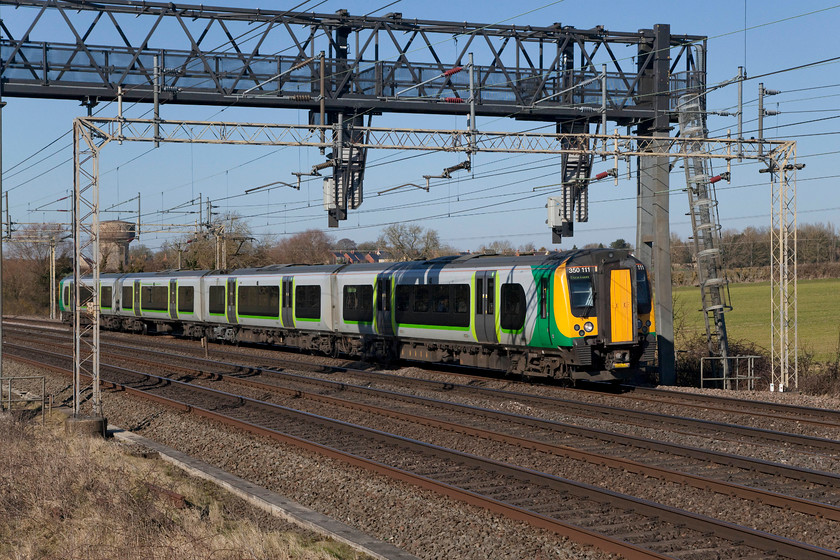 390111, LN 10.27 Crewe-London Euston (1U28, 7L), Roade Hill 
 The bright sunshine and clear blue sky belies the fact that it was very cold, there was vicious east wind blowing and the temperature was way below 'comfortable'. The fabled 'beast from the east' was only a day or so away! Here, 350111 passes Roade Hill between Northampton and Milton Keynes with the 1U28 10.27 Crewe to London Euston. 
 Keywords: 390111 1U28 Roade Hill