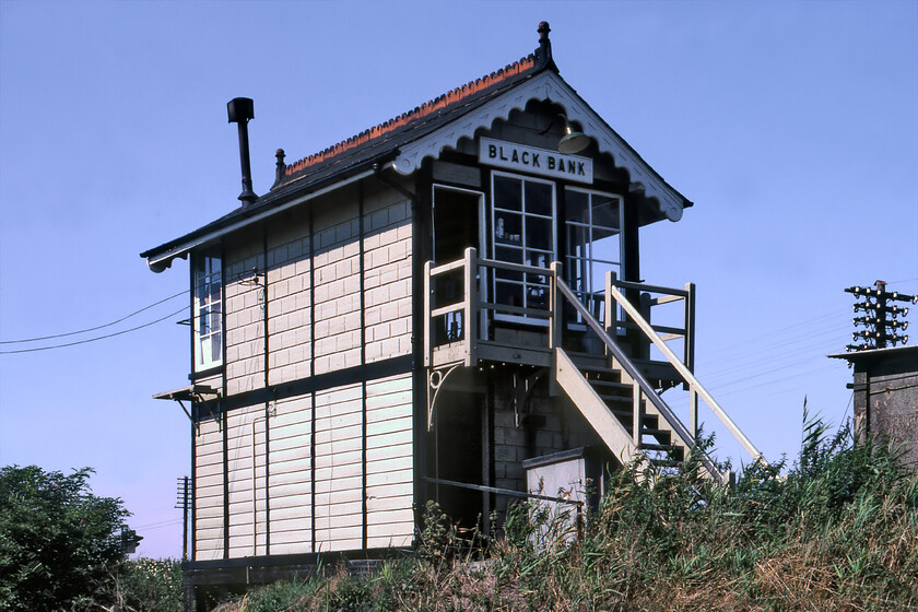 Black Bank signal box (GE, 1883) 
 Black Bank is a remote hamlet amongst many others in the Fens between Ely and March. Even more surprising was that it once boasted a station that was closed on 17.06.63 and a small good's facility with a shed that still stands. The Great Eastern signal box seen here dates from 1883 and stood on the Ely side of the level crossing that it also controlled. When it was closed in 1988 the top was removed by a local resident with the help of a small team and some primitive machinery and moved to his garden. I am not sure if it still exists. 
 Keywords: Black Bank signal box GE Great Eastern