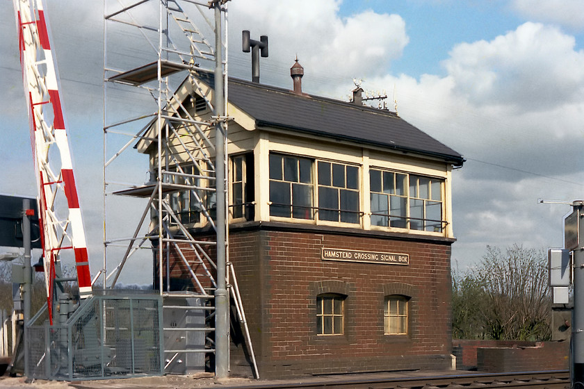 Hamstead Crossing signal box 12 hrs. prior to closure (GWR, date not known) 
 As it transpired, this was the last day of operation of Hamstead Crossing Signal box. It was being taken out of use at midnight as an intermediate block post between Newbury West and Kintbury. The scaffolding was erected so as to complete the installation of the CCTV cameras on their tall poles. The crossing was to be monitored and controlled by a new mini work station at Kintbury. Notice how shiny and new looking the barriers are! I remember the signallman shouting at me to move my ITT radio cassette recorder as he thought it was going to foul the barriers when they were lowered. 
 Keywords: Hamstead Crossing signal box 12 hrs. prior to closure GWR, date not known