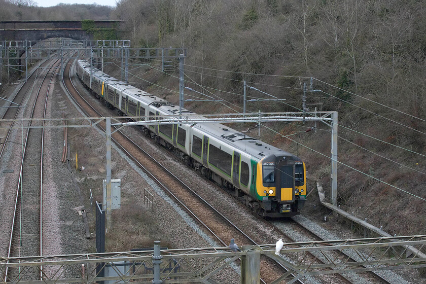 350265 & 350264, LN 14.25 Northampton-London Euston (2Y10, RT), A508 bridge 
 Over the coming few months the members of the Class 350/2 subset of this highly successful and reliable Desiro family of trains will end their time on the WCML as the Class 730s are introduced. Still wearing their London Midland livery from a number of years ago, sequentially numbered 350265 and 350264 pass through Roade working the 14.25 Northampton to London Euston 2Y10 service. With them soon to come off lease there appears to be no operator ready to take the Desiros on so they face an uncertain future. 
 Keywords: 350265 350264 14.25 Northampton-London Euston 2Y10 A508 bridge London Northwestern Desiro