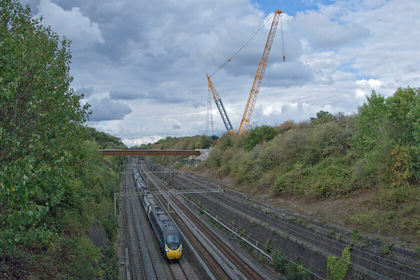 390042, VT 13.47 Liverpool Lime Street-London Euston (1A43, RT), Roade cutting 
 Overshadowed by a substantial crane towering above Roade Cutting 390042 heads south working Avanti's 1A43 13.47 Liverpool to Euston service. The crane has been involved with the installation of the new bridge girders that will carry Roade's bypass. The huge girders were lifted in over two Saturday night to Sunday morning possessions. 
 Keywords: 390042 13.47 Liverpool Lime Street-London Euston 1A43 Roade cutting Avanti West Coast Pendolino