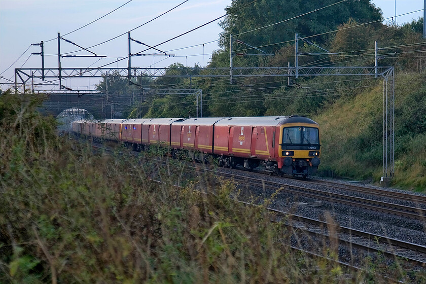 325004, 06.40 Willesden-Warrington (1F00), Roade Hill 
 325004 leads another two units as it heads north on the up fast line working the 06.40 Willesden PRDC to Warrington morning Royal Mail train. The train is seen near the village of Ashton in Northamptonshire with one of my favoured locations, Victoria bridge, in the background. 
 Keywords: 325004 06.40 Willesden-Warrington 1F00 Roade Hill Royal Mail